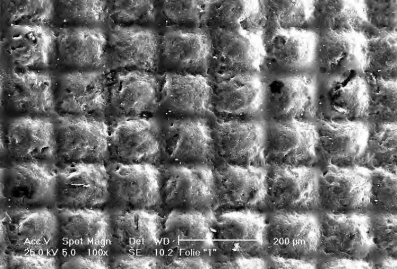 Scanning electron micrograph of a micro-embossed film surface with a square gravure pattern
